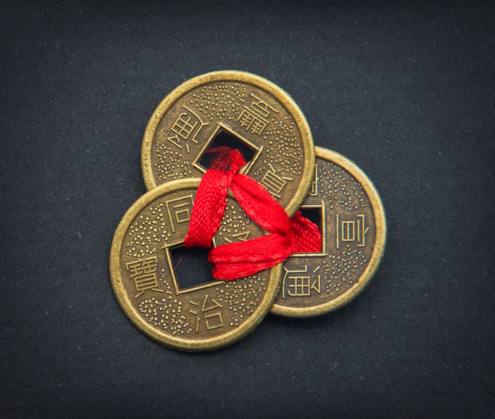 Detrás de la puerta principal cuelga un saquito o bolsita con monedas chinas, amarradas de su agujero con un listón rojo. Son buenas para atraer abundancia y buena suerte.