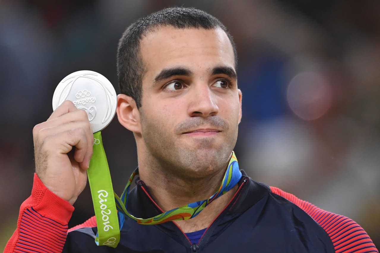 Leyva celebra en el podio su medalla en las barras paralelas.