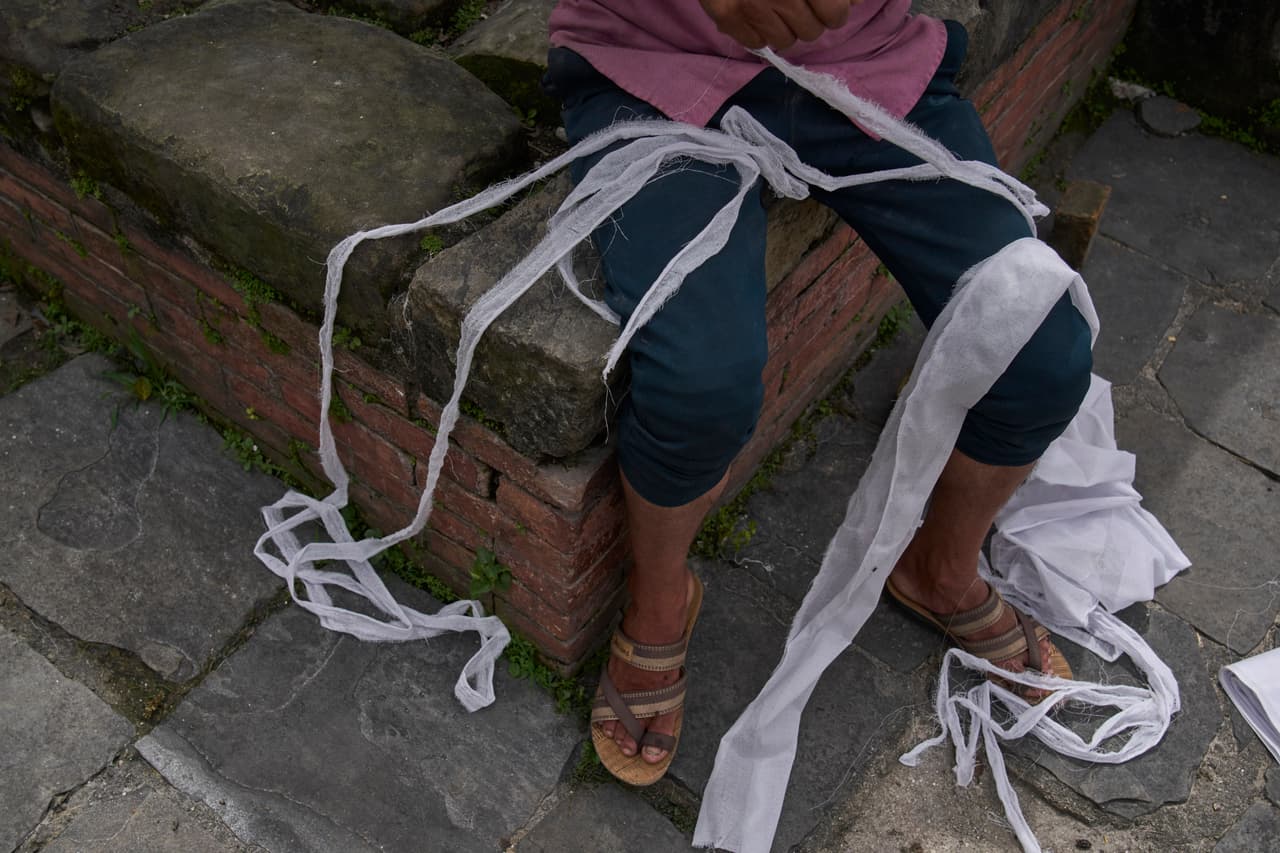 Un hombre prepara los materiales para los rituales de cremación de una persona desaparecida a causa de las inundaciones repentinas, durante un funeral simbólico a orillas del río Bagmati, cerca del templo de Pashupatinath en Katmandú, Nepal, el jueves 3 de septiembre de 2026.