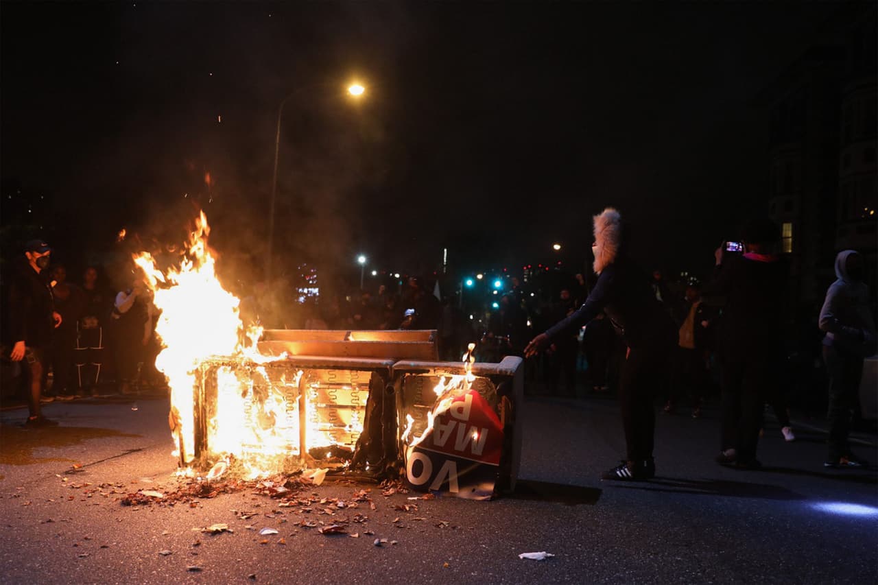 Los manifestantes se paran cerca de una barricada en llamas en Filadelfia. Los actos de vandalismo y violencia se produjeron en la sección de 
<a href="https://www.univision.com/local/philadelphia-wuvp/segunda-noche-de-saqueos-y-vandalismo-en-filadelfia-luego-del-asesinato-de-walter-wallace">Port Richmond</a>, donde la zona comercial en la avenida Aramingo y la calle Castor fueron el foco de atención.