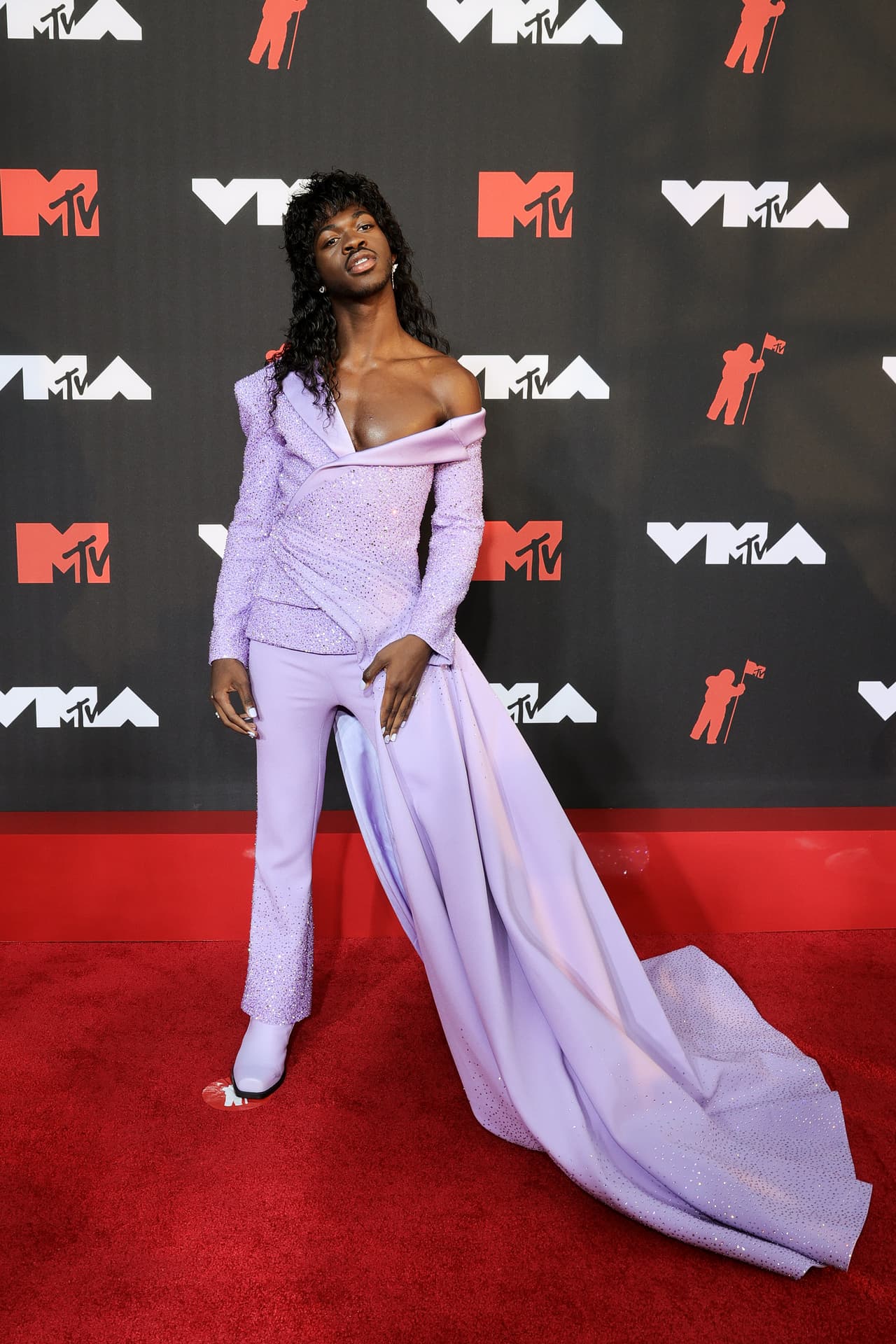 Lil Nas X optó por un 'look' andrógino con el que combinó un traje para caballero con una larga cola de un vestido para dama.