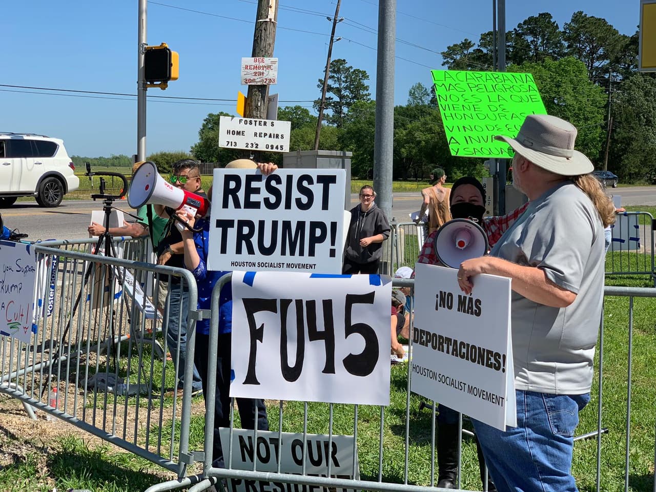 En una esquina opuesta al lugar donde se encontraban los simpatizantes, grupos de detractores coreaban consignas en contra de Trump y sostenían carteles con mensajes de protesta por la visita.
