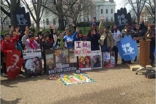 Estos manifestantes alzan su mano al preguntar quienes habían sido víctimas de las deportaciones