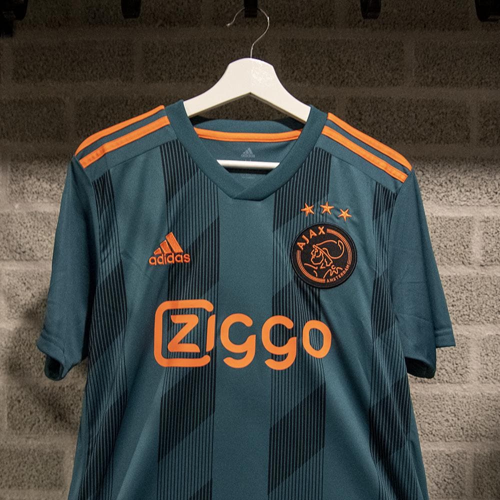 Después de que se conociera su playera titular para la próxima temporada, el Ajax ahora anunció su jersey alterno el cual estrenó este miércoles en el último juego de la Eredivisie 2018/19 ante el De Graafschap. El color verde es el protagonista en un tono oscuro acompañado de detalles naranjas.
