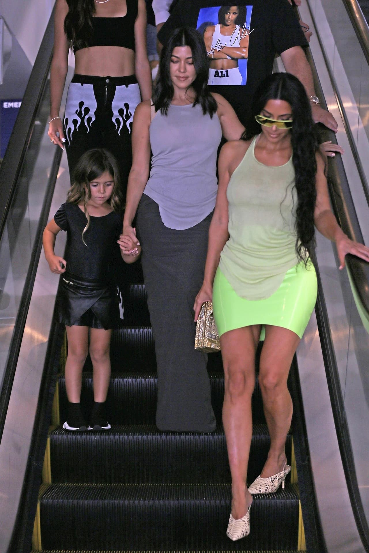 Kim Kardashian y Kourtney lucieron looks diferentes, aunque un modelo muy similar de camiseta. Kim prefirió una minifalda verde muy llamativa.