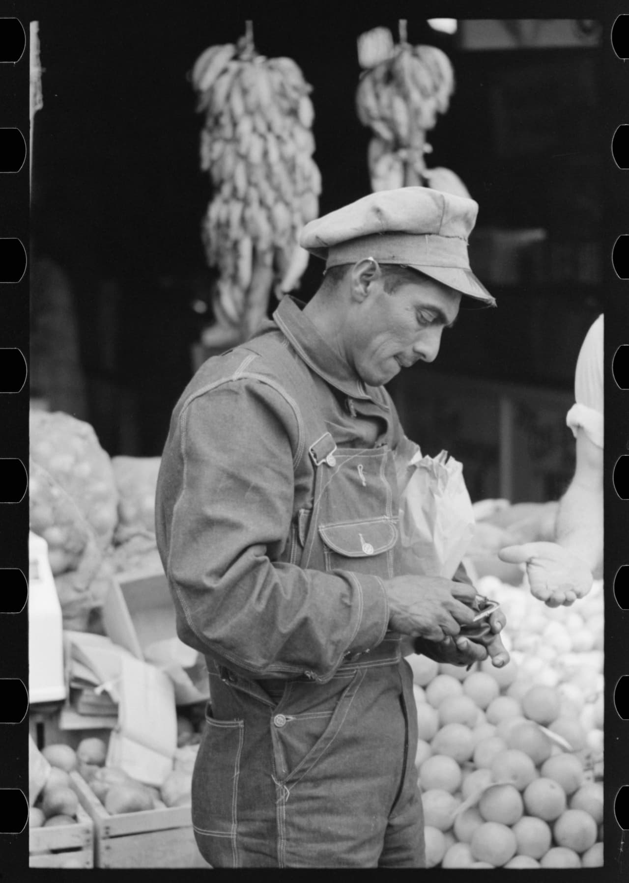 Trabajador pagando por mercancí en la plaza del mercado, Waco, Texas. 1939.
