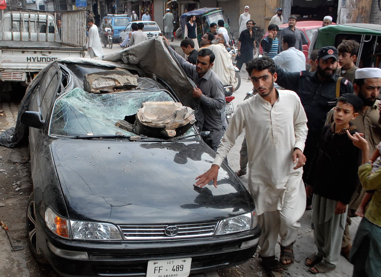 Un carro con fuertes daños por escombros en Peshawar (Pakistán).