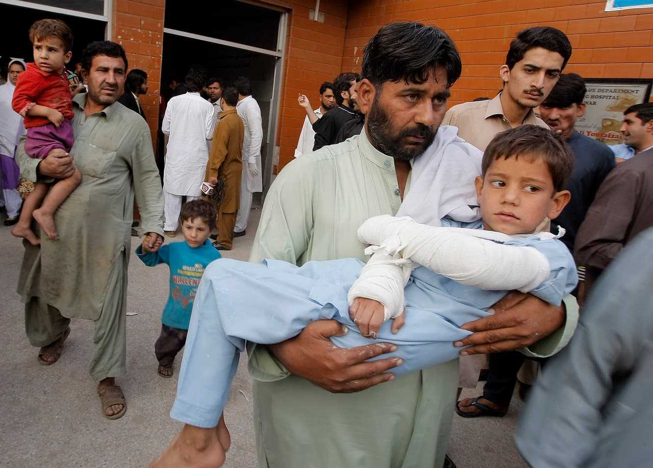 Un hombre carga a un niño herido en Pshawar (Pakistán).