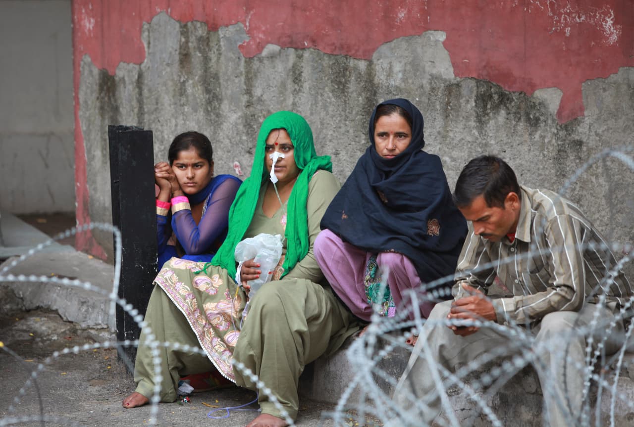 Un grupo de pacientes indios en las afueras de un hospital después de que un temblor se sintiera en Jammu (India).