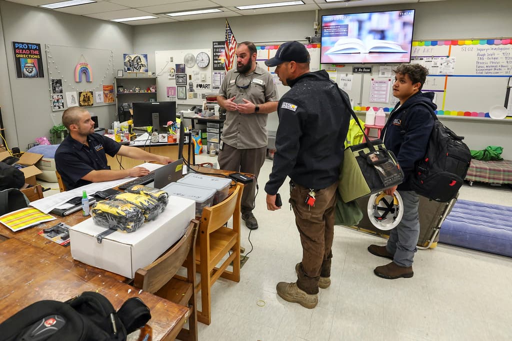 <b>Bien pertrechados: </b> Miembros de los servicios públicos del condado de Pasco se instalan en las aulas de un refugio contra huracanes en la escuela secundaria River Ridge, mientras pasa el huracán Milton, el miércoles 9 de octubre de 2024, en New Port Richey, Florida. (Foto AP/Mike Carlson)