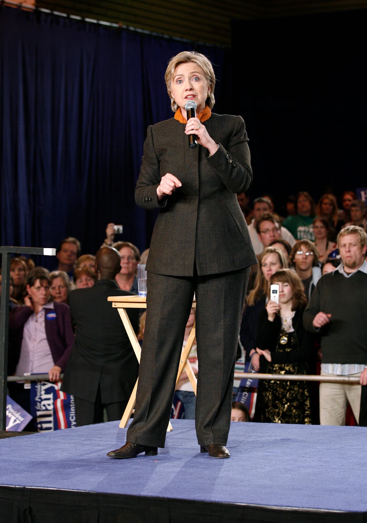 Como si supiera que le eran más favorecedores los colores claros que los tonos tierras, Hillary escogió trajes oscuros en pocas ocasiones. En febrero de 2008, en Washington, buscando el beneplácito de los delegados del estado usó este color tierra que llevó con un accesorio naranja sobre el cuello. (Jeff T. Green/Getty Images)