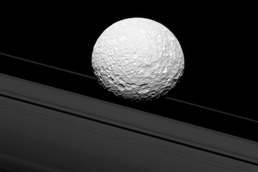 En esta fotografía pareciera que Mimas choca con los anillos de Saturno, sin embargo el satélite está a 28,000 millas de distancia. La sonda Cassini se encontraba 114,000 millas cuando tomó esta imagen.
