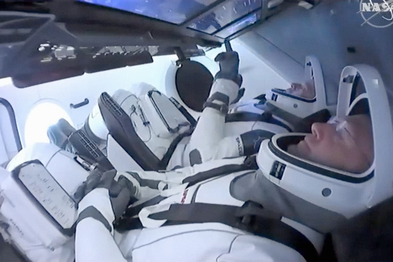 Los astronautas Douglas Hurley y Robert Behnken dentro de la cápsula Crew Dragon. Ambos volaron antes en misiones de NASA y son veteranos, Behnken de la Fuerza Aérea y Hurley, de los Marines.