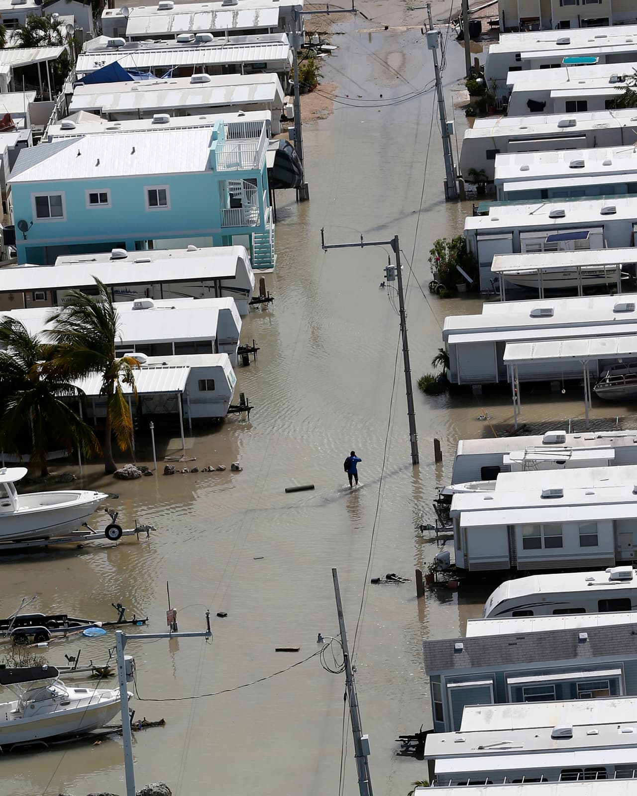 Un hombre caminando en medio de calles anegadas de Key Largo. El Centro Nacional de Huracanes dijo que Cape Sable y Captiva podrían experimentar paredes de agua de 15 pies.