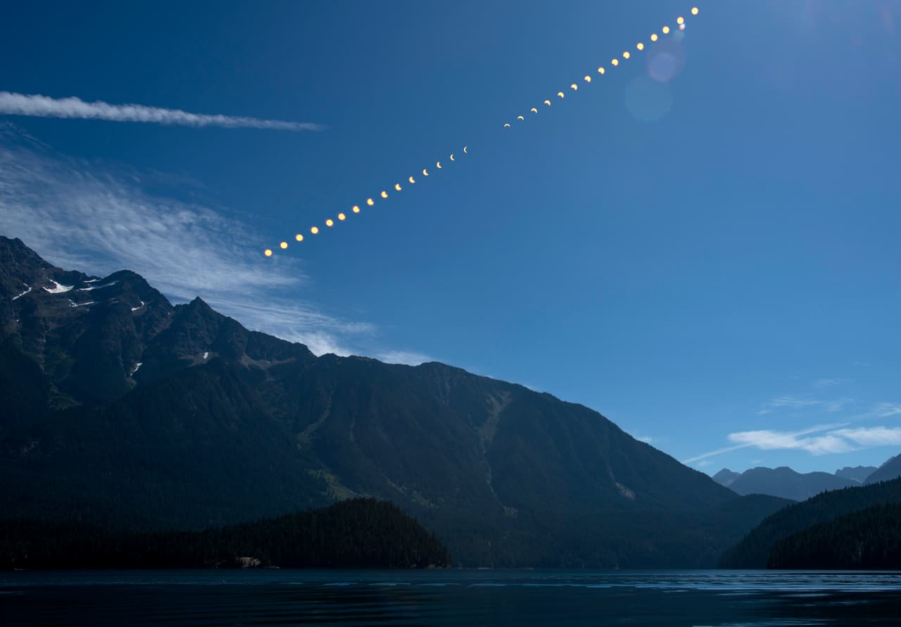 Varias fotografías superpuestas muestran la evolución del eclipse sobre las montañas del Parque Nacional Cascades en Rose Lake, Washington.