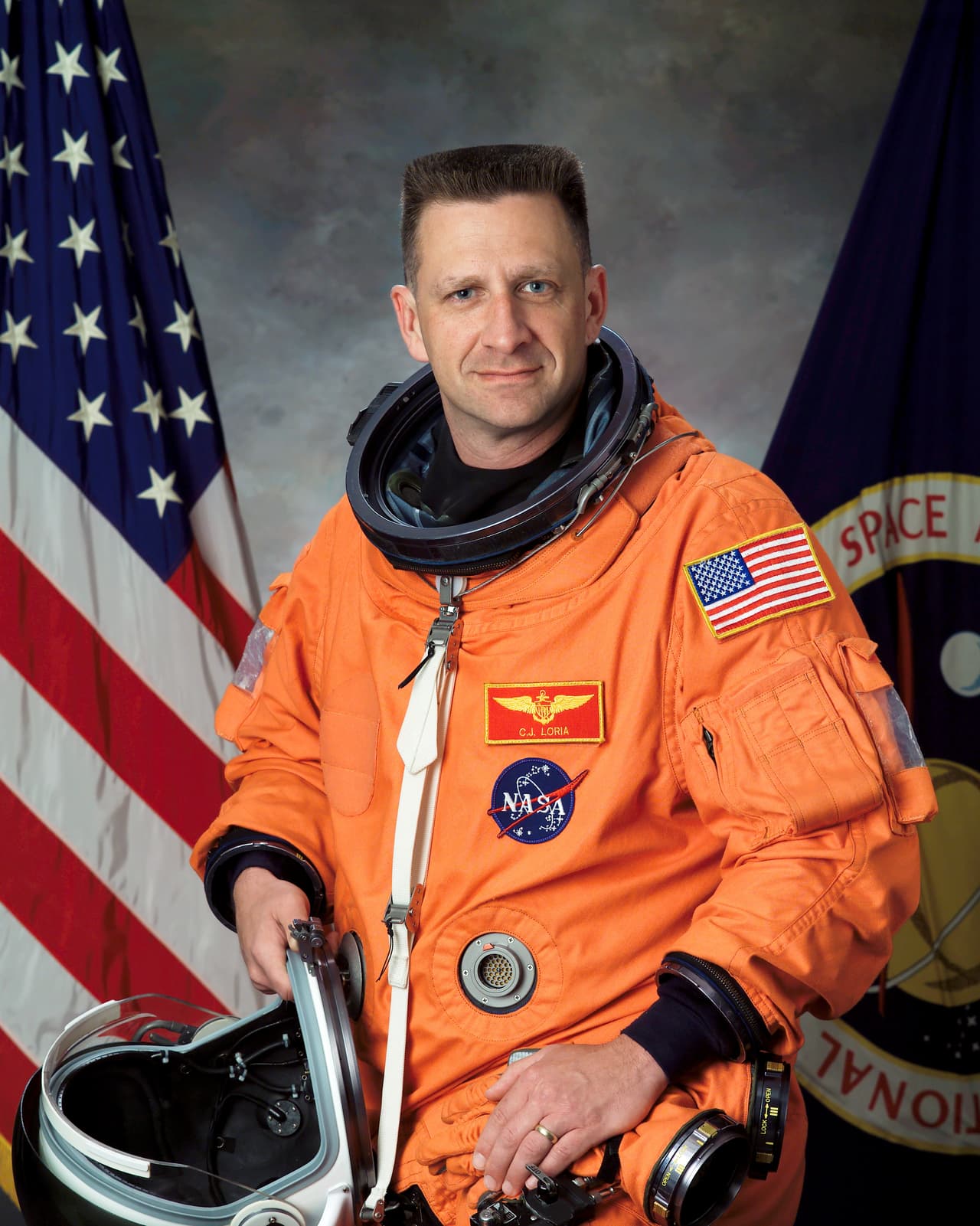 Christopher J. “Gus” Loria nació en Belmont, Massachusetts, de ascendencia mexicana. La NASA lo seleccionó como astronauta en 1996. Fue nombrado como piloto en la misión STS-113 del Transbordador Espacial, pero tuvo que solicitar su reasignación debido a una lesión que sufrió en su hogar. 
<br>