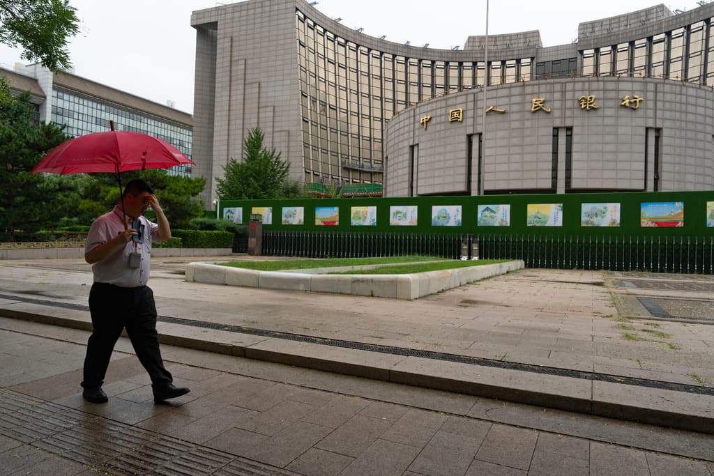 ARCHIVO - Un hombre pasa frente al banco central de China, en Beijing, el martes 25 de junio de 2024. (AP Foto/Ng Han Guan, Archivo)