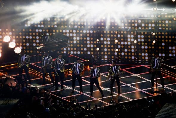 Un cuidado estilismo retro, una banda llena de energía y una particular mezcla de soul y rock sirvieron al cantante Bruno Mars para cautivar a la millonaria audiencia del Super Bowl durante el descanso de la gran cita anual del fútbol americano. Mars, de sólo 28 años y sobre quien planeaba la duda de si sería capaz de enfrentarse a un escenario de tal calibre, optó por un show directo y contundente. Tras una breve introducción a cargo de un coro de niños, un espectacular solo de batería sirvió para abrir el fuego y dar paso rápidamente al gran éxito "Locked Out of Heaven". Impecablemente vestido con una chaqueta dorada, despachó el tema junto a una banda con una amplia sección de viento que se lució en las coreografías. Sin más dilación, Mars descargó su segundo hit, "Treasure", y a continuación demostró su capacidad para fusionar el soul, el pop y el rock integrando en su espectáculo a los Red Hot Chili Peppers. La banda de Anthony Kiedis y Flea puso a saltar a todo el estadio Metlife con su clásico "Give it Away". Los rockeros californianos, a pecho descubierto como manda la tradición, solo necesitaron un par de minutos para demostrar que siguen en buena forma y ceder de nuevo el protagonismo a Mars.