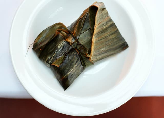 Cochinita pibil. Típica de del sureste mexicano, en ocasiones se cocina debajo de la tierra para conseguir un sabor más intenso. En este caso está envuelta en hoja de plátano para conservar su temperatura.