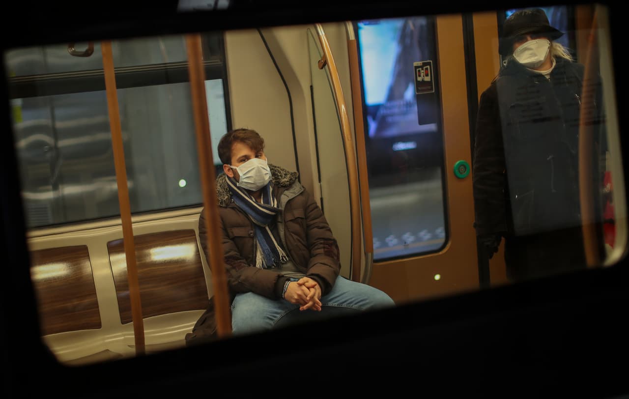 Personas con mascarillas y separadas entre sí viajan en el metro de Bruselas.