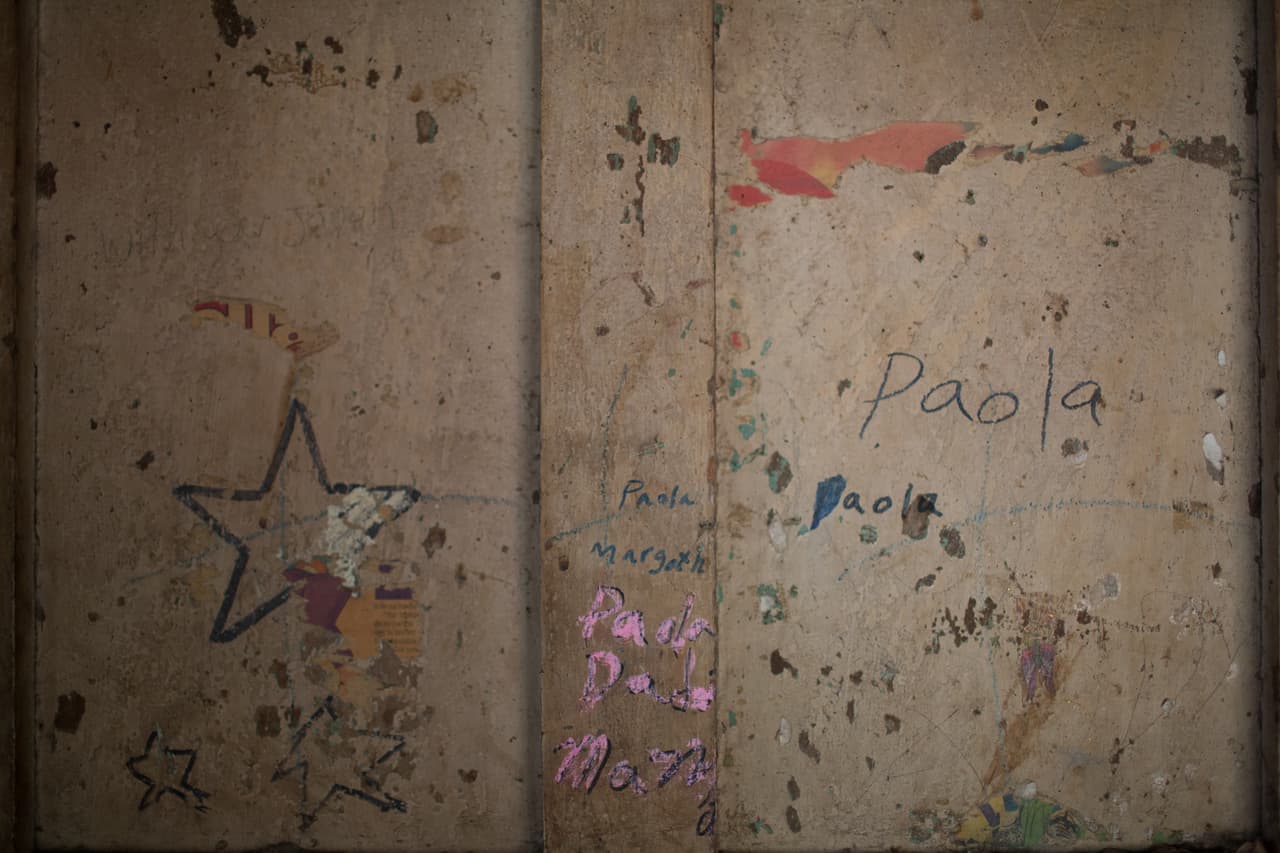 La puerta de la casa abandonada tiene dibujos hechos por las niñas. "Se han ido obligados por salvar la vida de sus hijos, y las de ellos mismos también. Es duro ver a sus hijas, sus nietos que se van", dice la abuela.