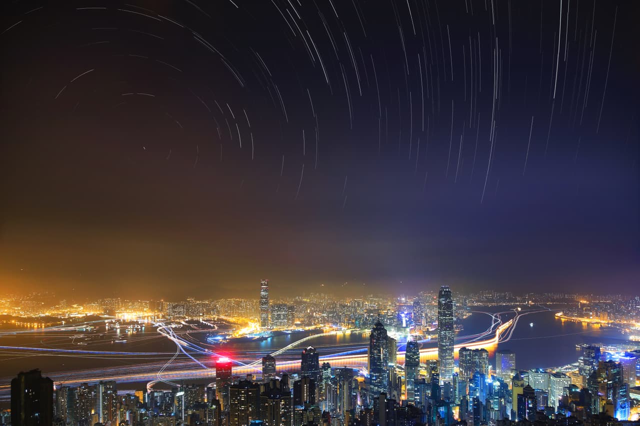 Bullicioso y pacífico. Tomada desde El Pico, la montaña más alta en la isla de Hong Kong, esta imagen muestra el contraste entre la ciudad bulliciosa y el pacífico cielo nocturno. la ‘niebla’ sobre la ciudad muestra cómo la contaminación lumínica nos impide de disfrutar el espectáculo que yace sobre nuestras cabezas.