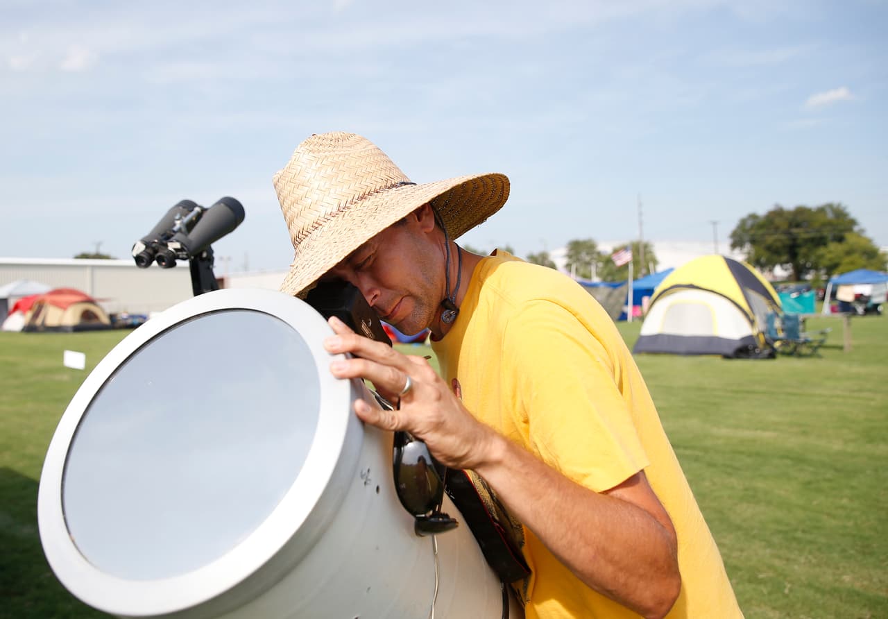 Brian Badgett coloca su cámara dentro de un telescopio para fotografiar el eclipse, en un campamento improvisado en la ciudad de Hopkinsville, Kentucky. Este es uno de los lugares donde podrá verse el fenómeno en su totalidad.