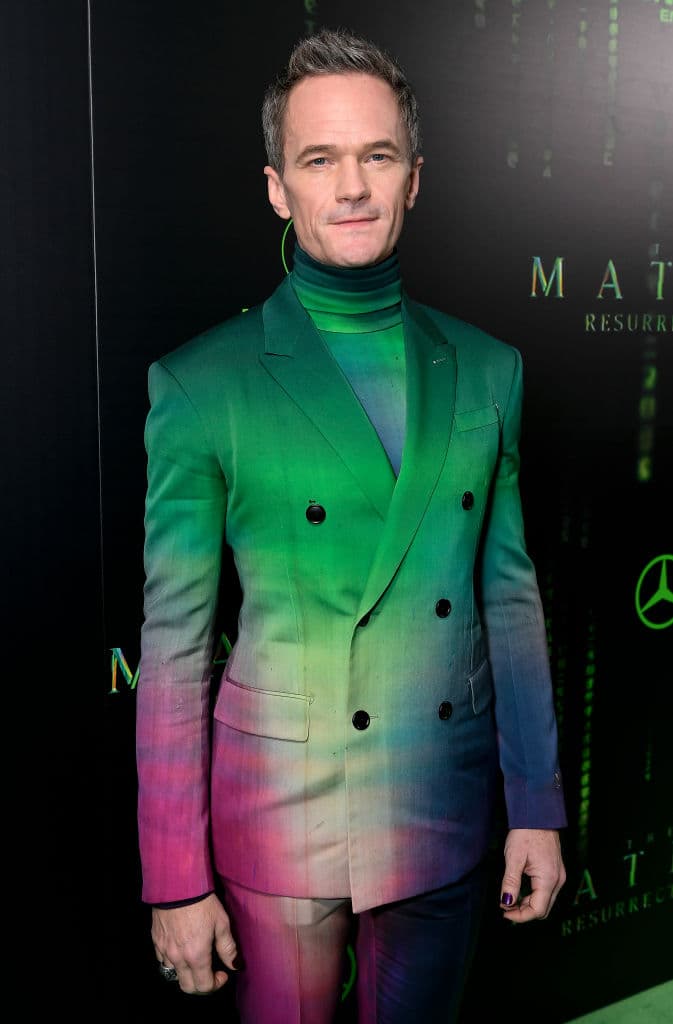 El traje de Patick Harris era Ombre en colores verde y morado que se degradaban entre sí y lo combinó con una playera con cuello de torturga en el mismo estilo de colores y las uñas pintadas de negro.