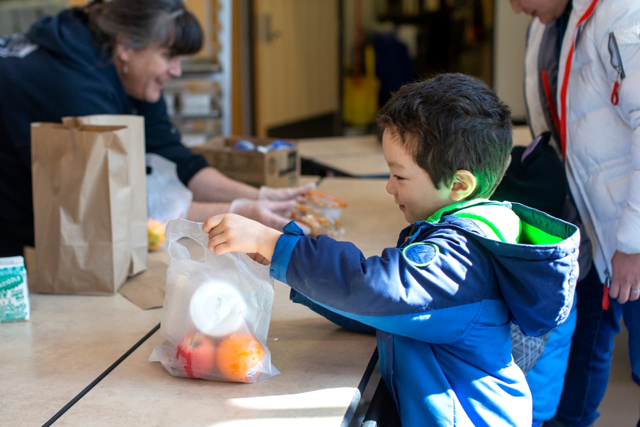 En esta imagen, el pequeño Tyden Brownlee, de 5 años, recoge su almuerzo gratuito en la escuela primaria Olympic Hills, en Seattle.