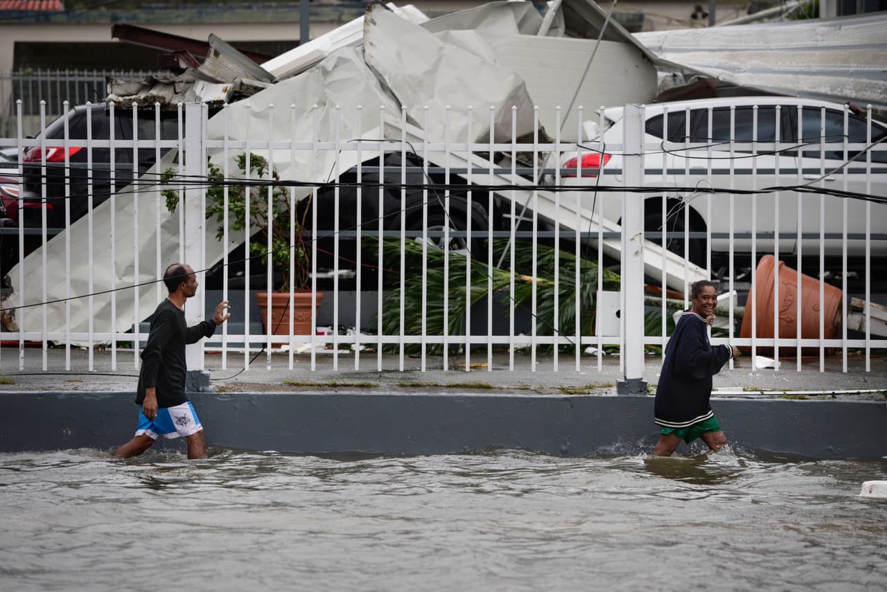 Residentes de Humacao, Puerto Rico, caminan por una calle inundada tras el paso del huracán María.