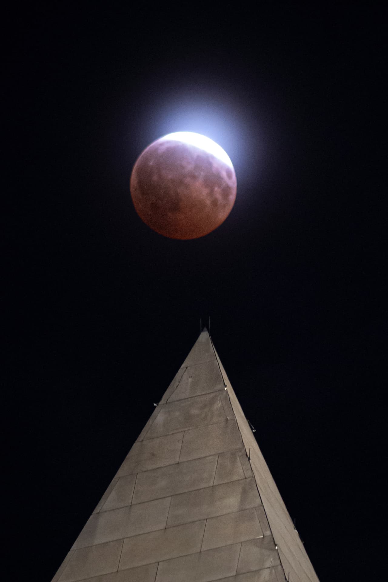 Un eclipse lunar se observa a través de nubes ligeras sobre el Monumento a Washington en Washington, durante la madrugada del viernes 28 de agosto de 2026.