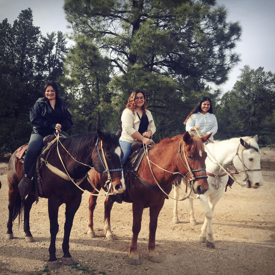 Yelitza montando a caballo con sus dos hijas