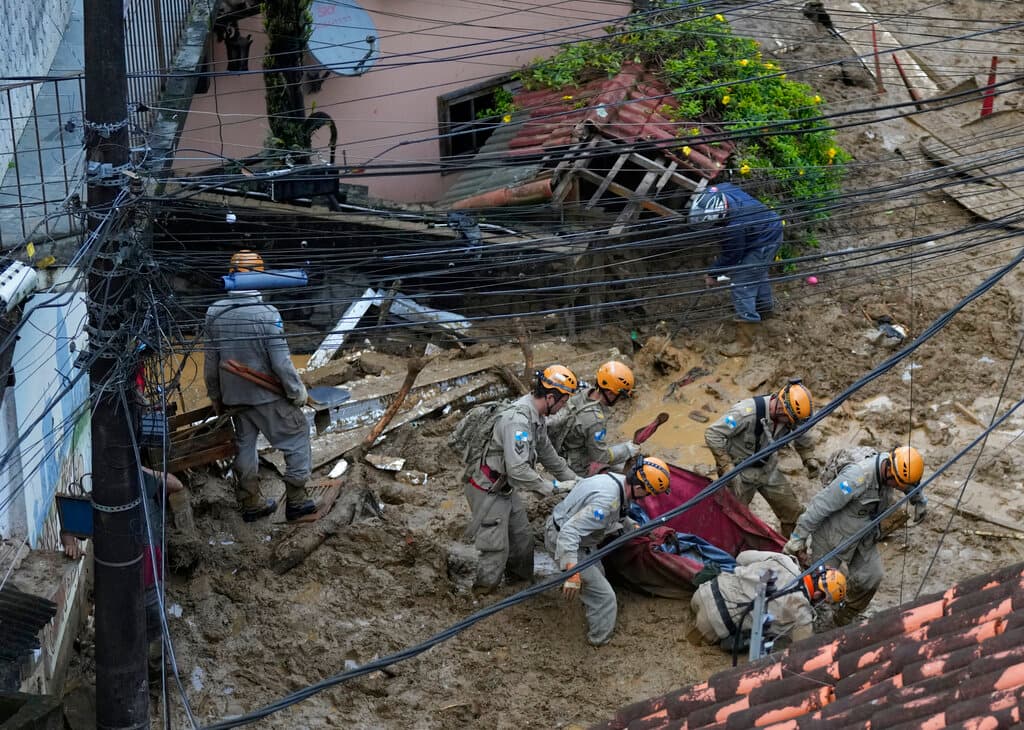 Rescatistas trasladan el cadáver de una víctima de un deslave. El gobernador de Río de Janeiro, Claudio Castro, explicó en una conferencia de prensa que las lluvias fueron las peores registradas en la ciudad desde 1932. “Nadie podía predecir lluvias tan intensas como estas", apuntó Castro. 
<br>