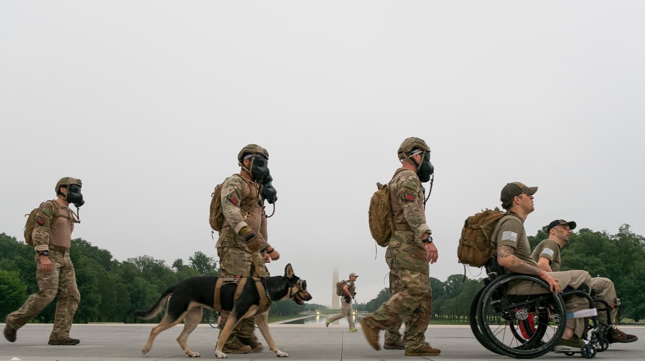 Veteranos del grupo "Ruck to Remmber" que brindan apoyo a otros soldados caminan por la esplanada en Washington DC, en ruta al Cementerio Nacional de Arlington. (AP Photo/J. David Ake)