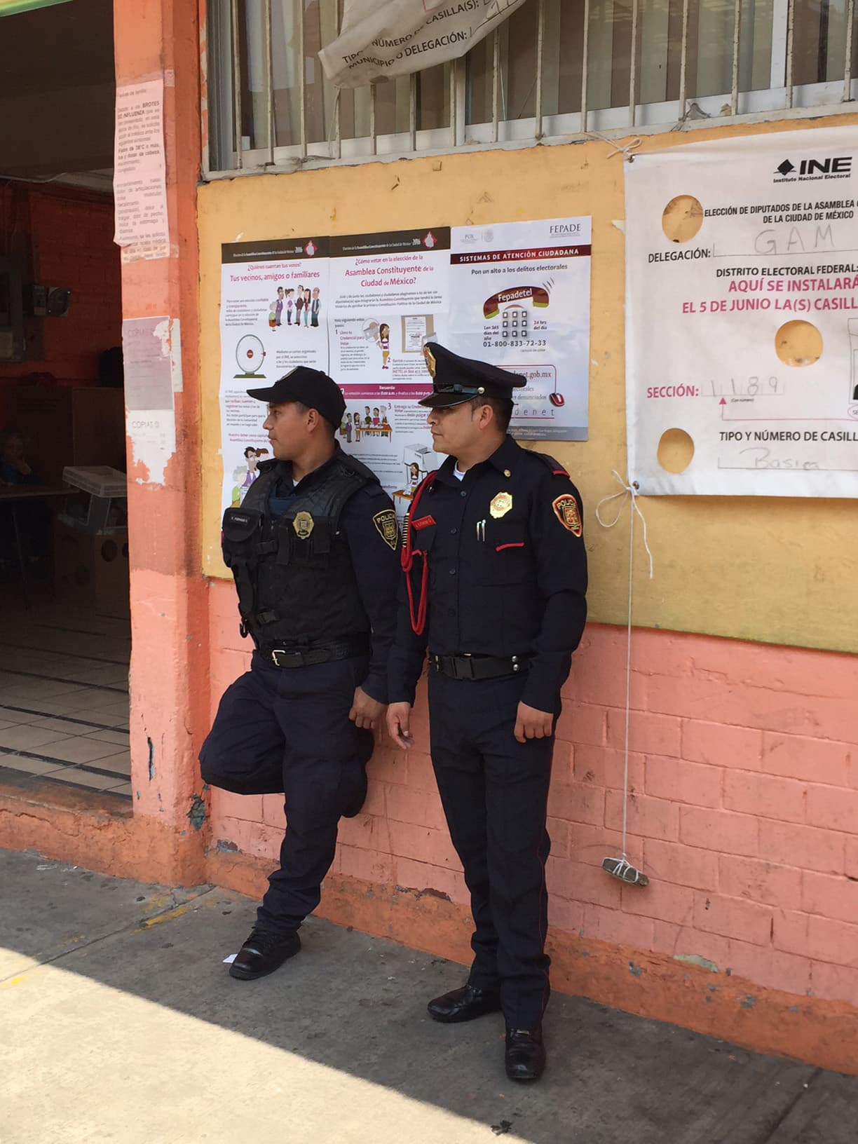Policías vigilando el exterior de una casilla electoral.