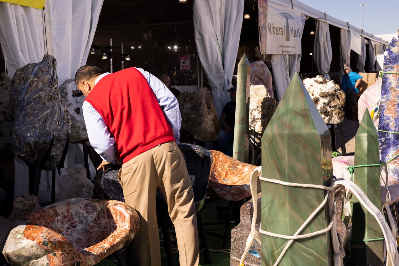 A visitor inspects some large pieces on display during the 22nd Street Mineral, Fossil, Gem, and Jewelry Show in Tucson, Arizona, on January 28, 2023. (Photo by RYAN COLLERD / AFP) (Photo by RYAN COLLERD/AFP via Getty Images)