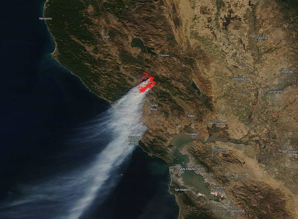 El incendio Kincade, que afecta al condado de Sonoma, visto desde un satélite de NASA el 28 de octubre de 2019. Los vientos de Santa Ana han sido tan extraordinariamente secos, potentes y prolongados que el Servicio Meteorológico Nacional creó un nuevo nivel de alerta, emitiendo una "advertencia de bandera roja extrema" en los condados de Los Ángeles y Ventura.