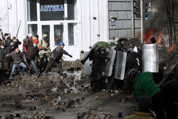 La policía ucraniana cercó hoy a los manifestantes en el corazón de las protestas opositoras de la plaza de la Independencia de Kiev (Maidán), tras una jornada en la que murieron 14 personas en los disturbios que estallaron en la capital. Víktor "Yanukóvich se ha convertido en un presidente sangriento", aseguró hoy el dirigente opositor Vitali Klitschkó en un llamamiento a los países democráticos para que intervengan en Ucrania y frenen la violenta confrontación. Según se acercaba la medianoche, los temidos Berkut, el destacamento antidisturbios, estrechaban el cerco en torno a los miles de manifestantes concentrados en el Euromaidán, bastión de las protestas desde el pasado 21 de noviembre. "Los extremistas de la oposición han cruzado la línea roja; matan a inocentes en la calles de la capital de Ucrania, vejan a mujeres, queman edificios y automóviles. Y si los disturbios continúan, nos veremos obligados a actuar con firmeza", rezaba el ultimátum del Servicio de Seguridad y el Ministerio del Interior de Ucrania. Advierten a los americanos que se queden dentro de las casas y de nuevo se sienten explosiones en la ciudad.