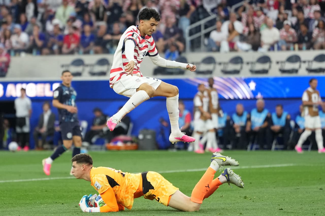 El estadounidense Ricardo Pepi salta sobre el portero paraguayo Orlando Gill durante el partido de fútbol.