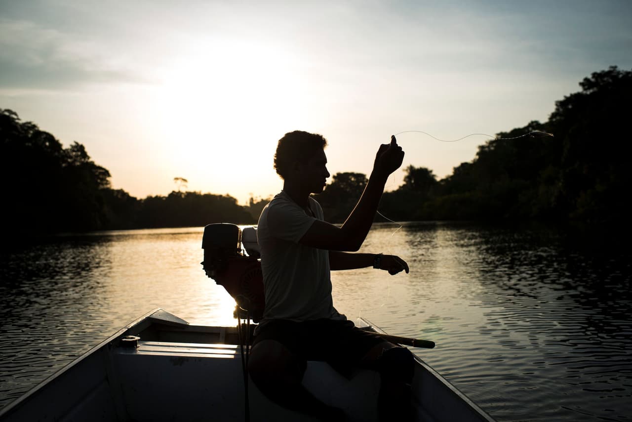 Henriques P. Morois, 20, fishes on the Xingu River. Fishing has sustained the Juruna of the Volta Grande for decades, both for sustenance and for commerce. Since the completion of the Belo Monte Dam they have seen fish populations plummet and one ornamental fish they once caught and sold for good money, the Zebra Pleco, which only lives on this one stretch of river, is now endangered and prohibited to fish. Dec 8, 2016.