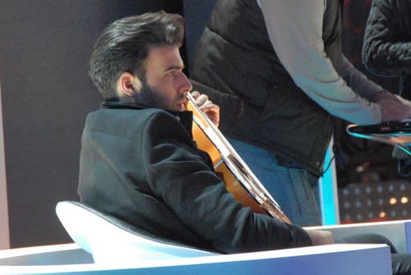 Jen prestaba atención mientras sostenía una guitarra.