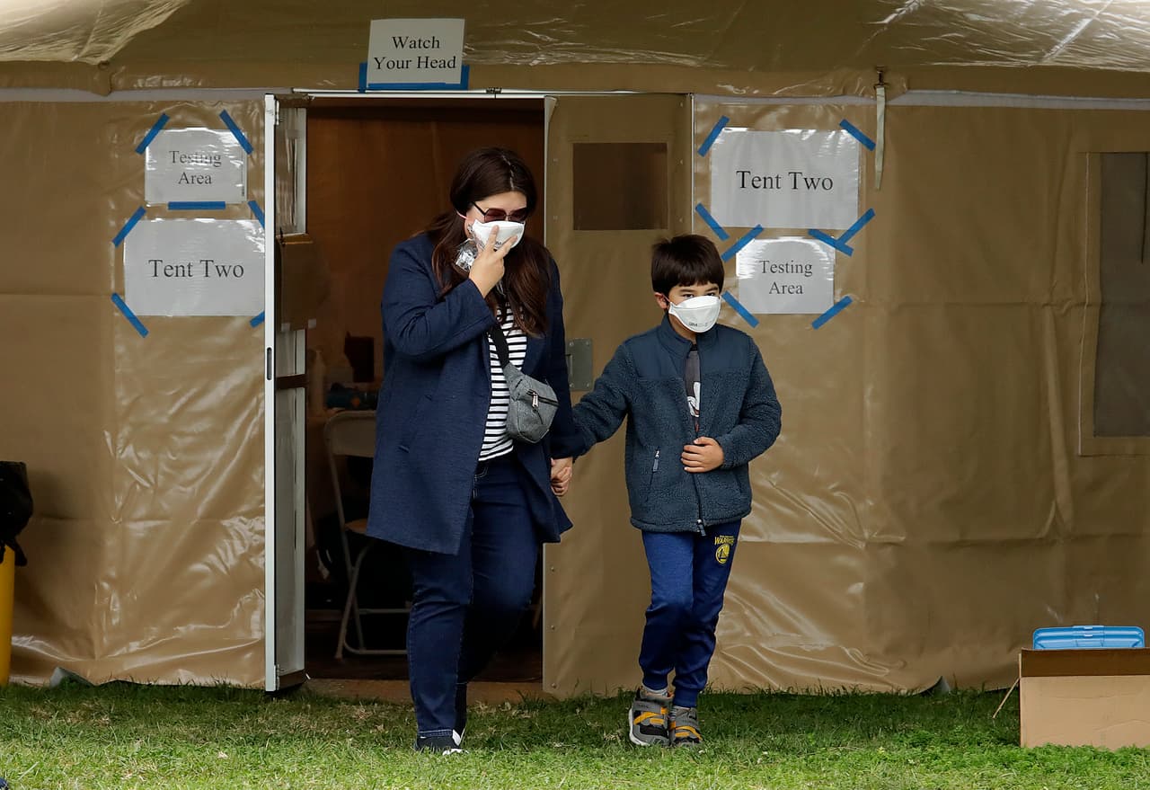Una mujer y su hijo salen de una estación móvil luego de haberse sometido a la prueba de coronavirus en Hayward, California. Hasta este jueves, 54 personas han dado positivo al covid-19.