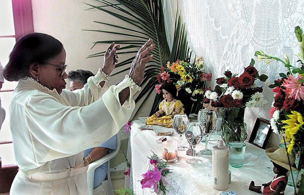La forma de los mortales de comunicarse con los orishas es mediante rezos, ritos, canciones, posesiones y ofrendas, que muchas veces incluyen sacrificios. En esta imagen, santeros derraman la sangre de una cabra en una ceremonia de iniciación en Habana.