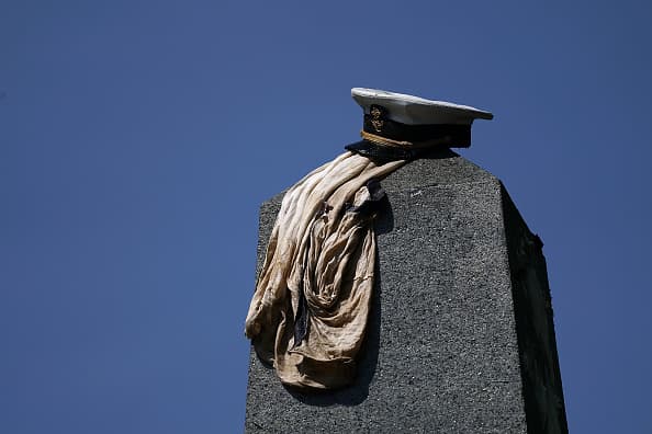 La gorra militar del uniforme de gala, conocida como quepis, debe estar en lo alto del monumento.