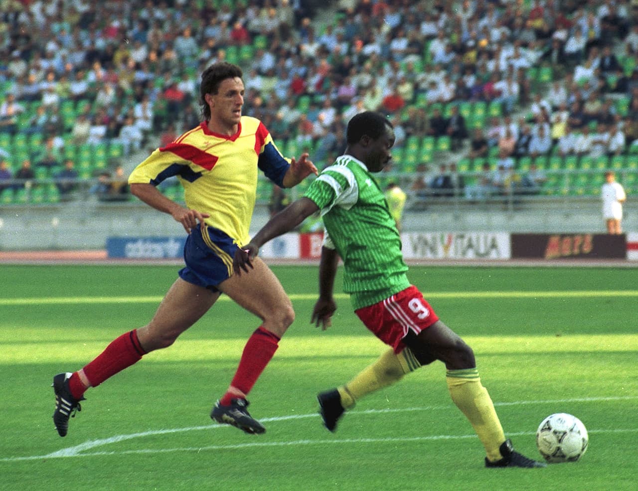 La foto de archivo del 14 de junio de 1990 muestra a Roger Milla, de Camerún, a la derecha, a punto de marcar el primero de sus dos goles contra Rumania, mientras el defensor rumano Gheorghe Popescu intenta detenerlo, durante el partido de la Copa Mundial en Bari, Italia.