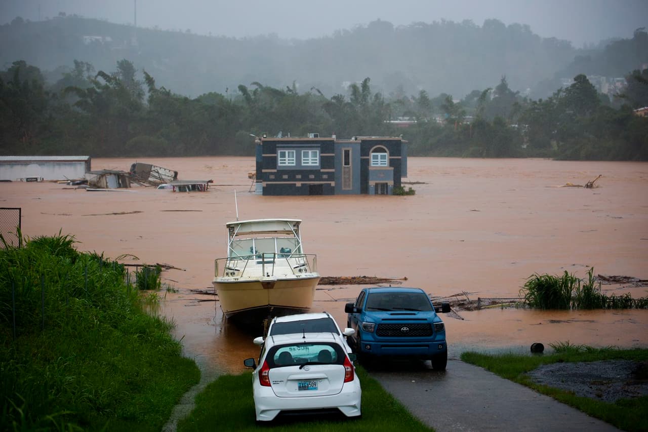 El gobernador Pierluisi declaró que los daños del huracán eran "catastróficos". En la foto, unas personas esperan dentro de su casa a ser rescatadas de la inundación que dejó el huracán.