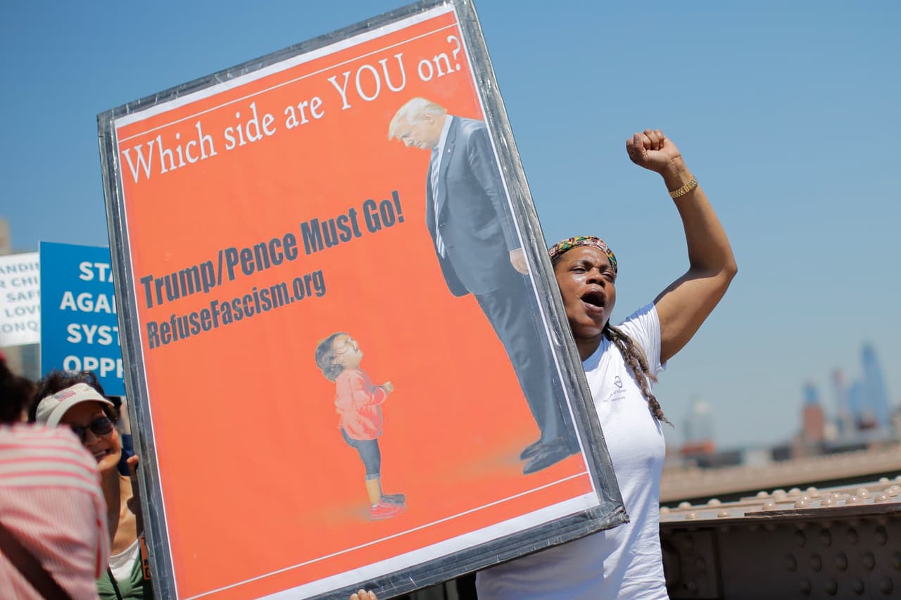 "¿De qué lado estás, TÚ? Trump y Pence deben irse", se lee en esta cartelera en una protesta por la reunificación familiar en Nueva York (Eduardo Muñoz Alvarez/ AFP/Getty).