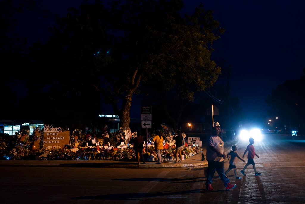 Familiares cruzan la calle después de visitar el memorial de la escuela Robb.