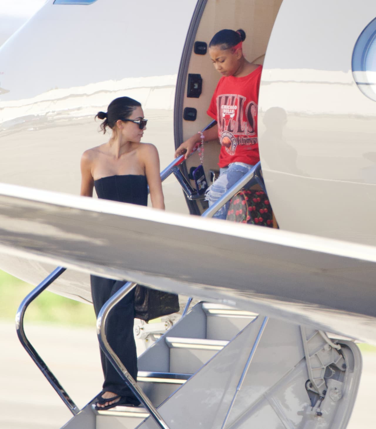Para su largo viaje, la famosa niña optó por utilizar un ‘outfit’ desenfadado, compuesto de jeans ‘rotos’, una camiseta ‘oversize’ de los Chicago Bulls y sandalias.