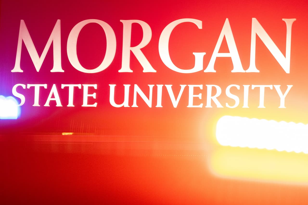 Police lights are reflected in a sign for Morgan State University as the entrance to the school is blocked off following reports of a shooting Tuesday, Oct. 3, 2023, in Baltimore. (AP Photo/Julia Nikhinson)